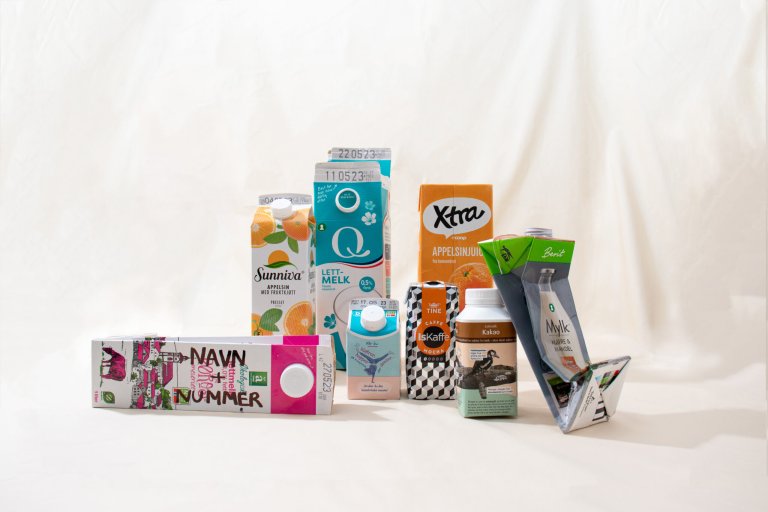 Kartonger i forskjellige varianter er oppstilt foran et hvitt lerret.