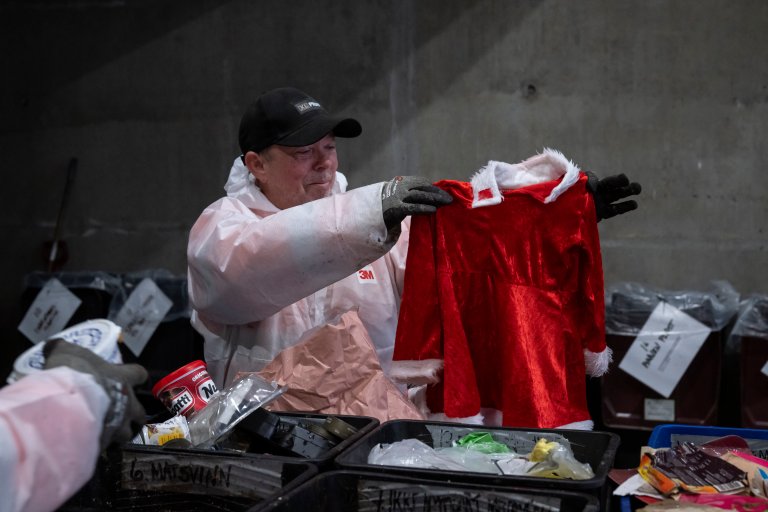 Mann som tar opp brukbar tekstil fra restavfallet