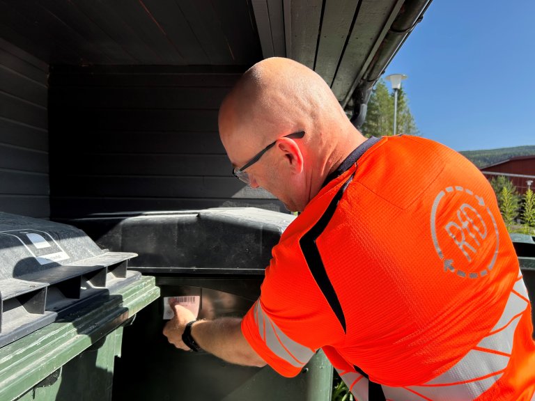 Mann i RfD-uniform merker en avfallsbeholder med en lapp.