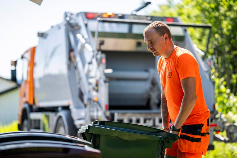 En renovatør flytter en beholder.